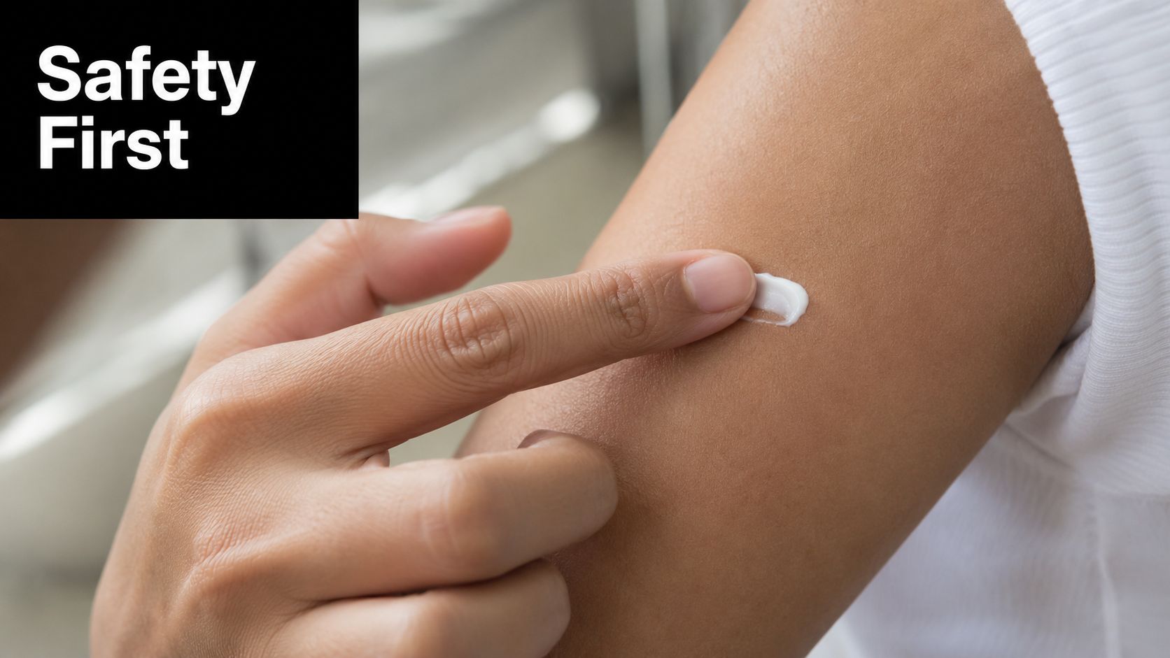 A person applying a small amount of white cream onto their upper arm with their finger.