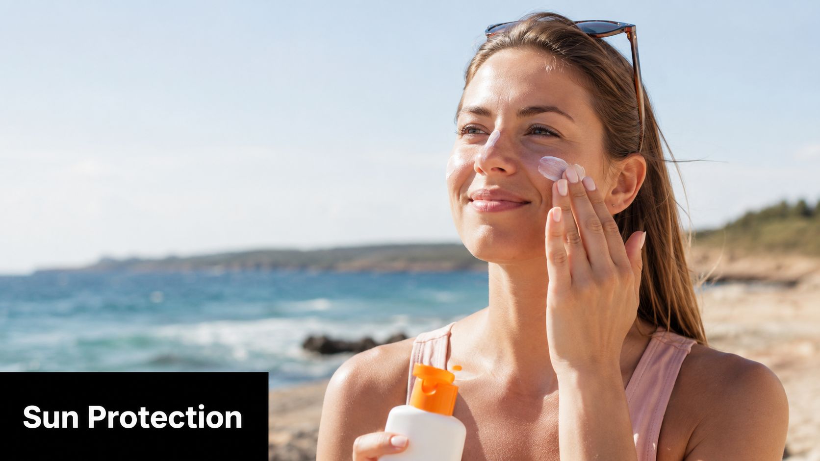 A woman applying sunscreen to her face on a sunny beach to protect against hyperpigmentation.